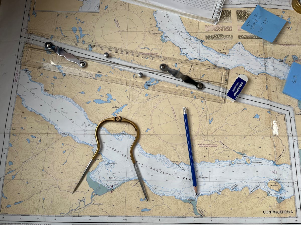 Carte marine SHOM avec compas à pointes sèches, règle Cras et crayon — outils de la formation théorique au permis bateau